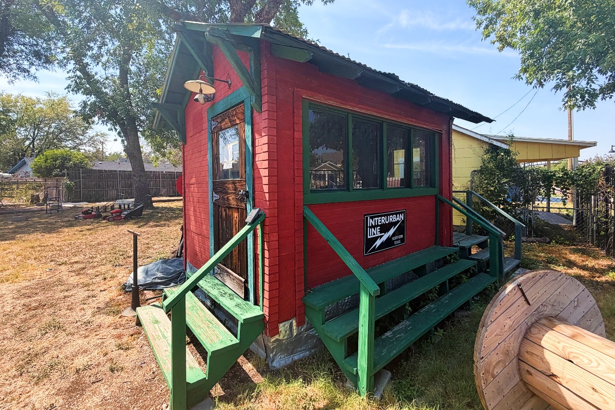 The historic red railroad ticket booth with green trim at The Keller Depot.